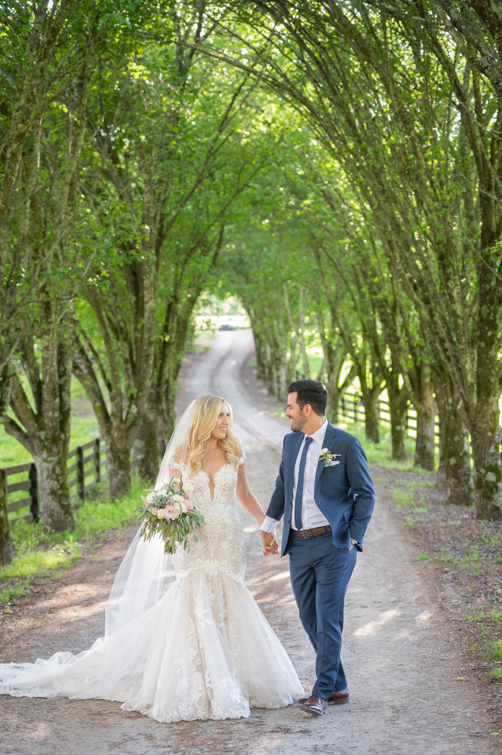 wedding couple under a row of trees